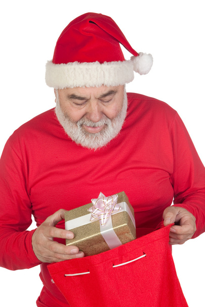 grappige santa claus nemen een geschenk uit zijn zak - Foto, afbeelding