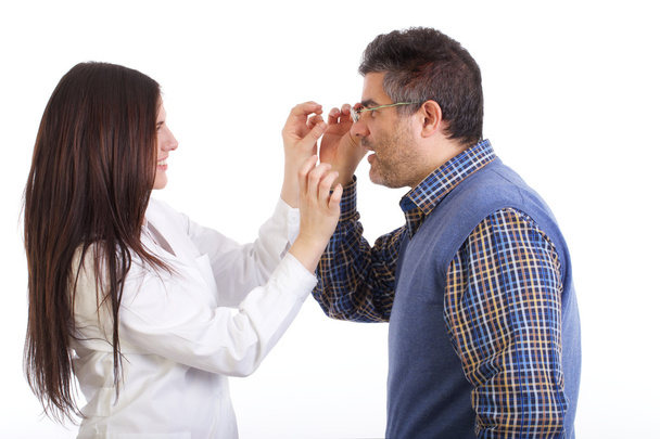 optician trying on glasses to a customer - Φωτογραφία, εικόνα