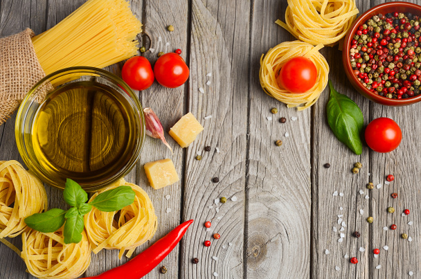 パスタ、野菜、ハーブ、素朴な木のテーブルでイタリア料理のスパイス. - 写真・画像