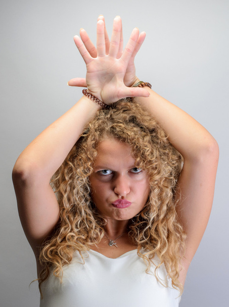 young funny curly woman making funny faces, put hands under head - Photo, Image