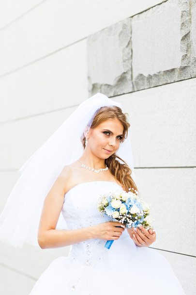 Retrato de novia joven en vestido blanco con un ramo de bodas
 - Foto, imagen