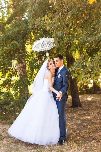 Pareja casada sosteniendo paraguas blanco
 - Foto, Imagen
