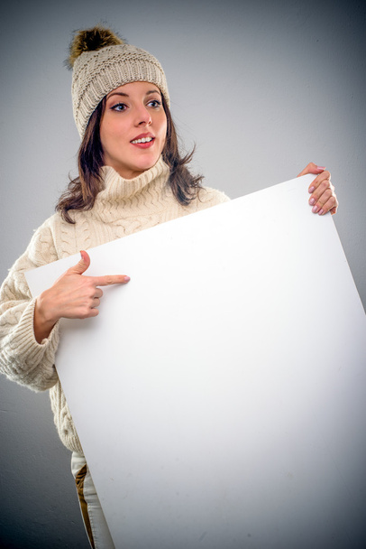 Pretty young woman pointing to a blank sign - Photo, Image