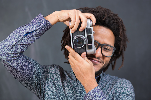 Portrait of a smiling afro american man making photo on retro ca - 写真・画像