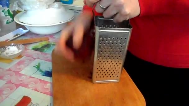 woman frays beets on a grater - Materiał filmowy, wideo