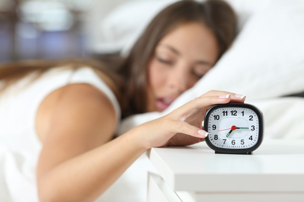 Wake up of an asleep girl stopping alarm clock - Foto, immagini