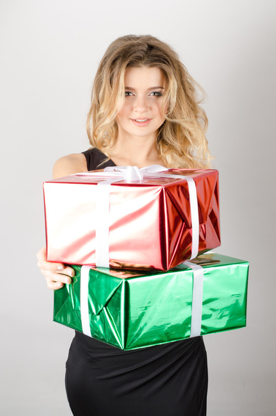 woman gives presents in a black dress - Foto, afbeelding