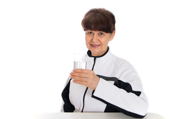 Good looking mature woman with glass of water posing after her sport session - Foto, Imagem