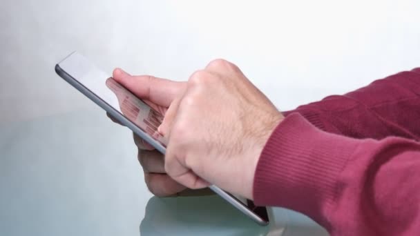 Hombre adulto joven hojeando aplicaciones de tabletas
 - Imágenes, Vídeo