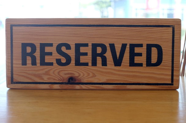 Gereserveerde houten teken op tafel - Foto, afbeelding