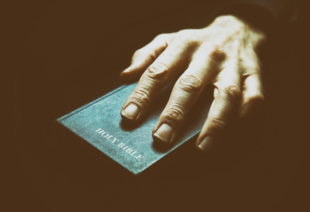 Mannenhand op de Heilige Bijbel  - Foto, afbeelding