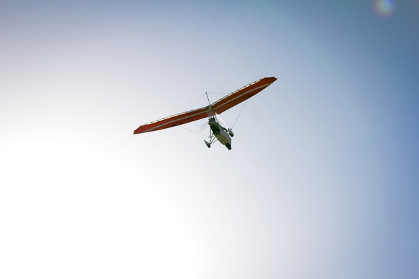 Моторизованный дельтаплан, парящий в голубом небе
 - Фото, изображение