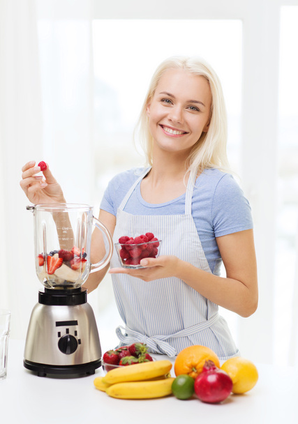 smiling woman with blender preparing shake at home - Фото, зображення