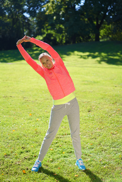 Attractive young woman exercising in a park - Fotoğraf, Görsel