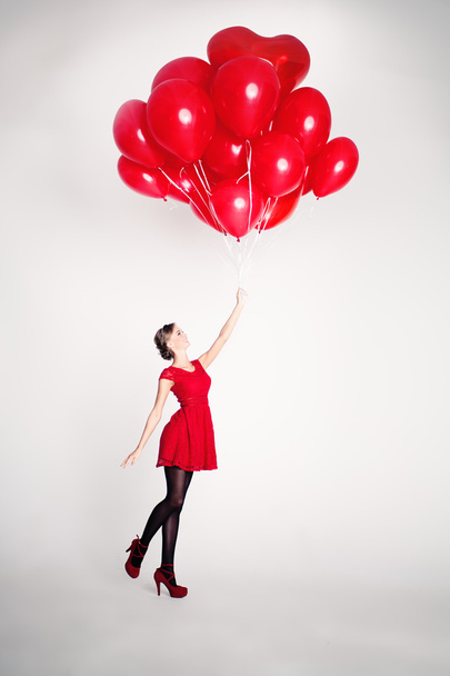 Huoleton nuori nainen punaisilla ilmapalloilla
 - Valokuva, kuva