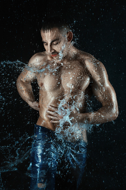 Man in splashes and drops of water. - Foto, imagen