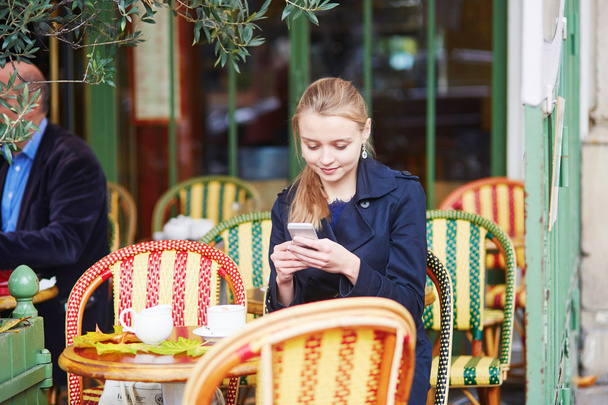 Beautiful young woman drinking in Parisian outdoor cafe - Фото, зображення