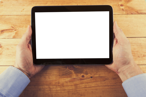 digitales Tablet mit leerem Bildschirm in der Hand auf dem Holztisch - Foto, Bild