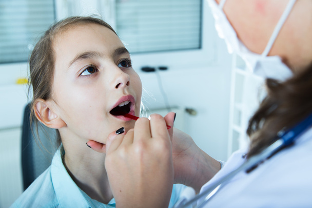 Doctor check throat of little girl..toned image. - Fotografie, Obrázek