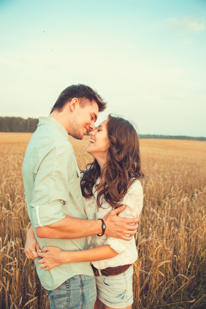 Young couple in love outdoor.Stunning sensual outdoor portrait of young stylish fashion couple posing in summer in  field - Photo, Image