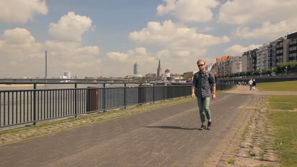 Hipster tourist is walking along European embankment. - Footage, Video