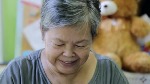 Felice donna anziana asiatica sorridente di fronte alla fotocamera
. - Filmati, video