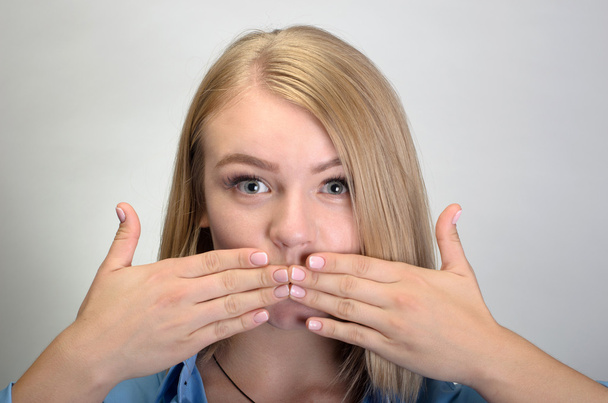schöne junge Frau, die den Mund mit ihren Händen bedeckt - Foto, Bild
