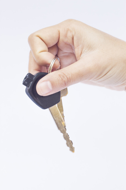 Hand with a car key isolated on white background - Foto, afbeelding