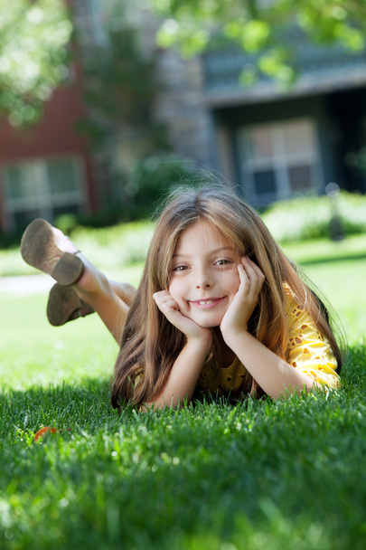 portrait of little girl laying on the grass in summer environmentportrait of little girl laying on the grass in summer environment - Fotó, kép