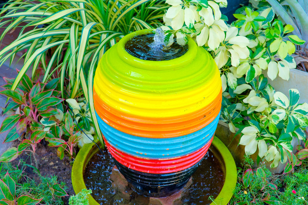jarra cerâmica com água no jardim verde
 - Foto, Imagem