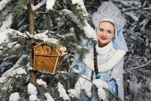 Snegurochka (Snow Maiden) with gifts bag in the winter forest - Photo, Image
