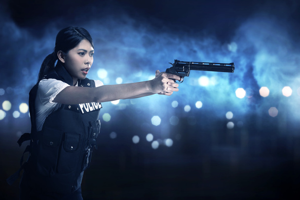 Beautiful police woman holding gun - Фото, изображение