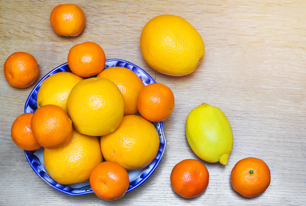 Апельсины и мандарины в красивой керамической вазе
. - Фото, изображение