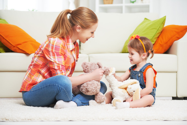 feliz familia madre e hija niña jugando con juguete Ted
 - Foto, Imagen