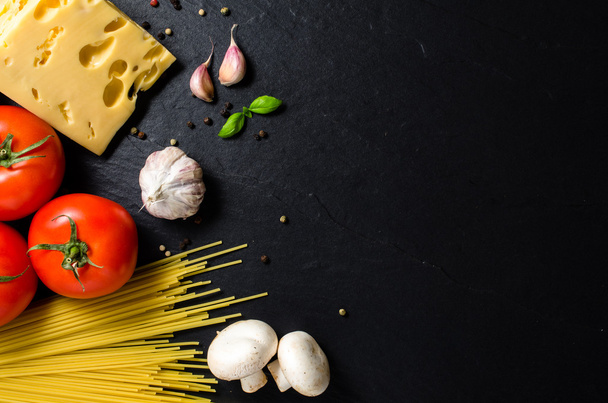 Spaghetti ingredients over dark background - Fotoğraf, Görsel