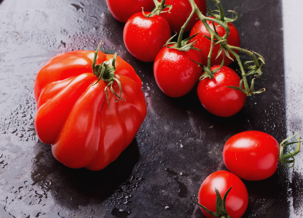 Organische rijpe tomaten op zwarte achtergrond - Foto, afbeelding
