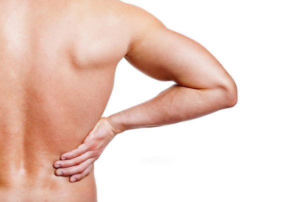 Muscular young man holding his back in pain - Foto, immagini