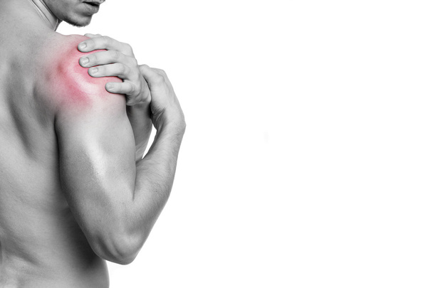 Fit man holding his shoulder in pain - Photo, Image
