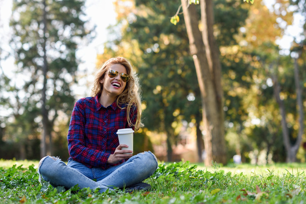 Beautiful woman drinking coffee in the park - Fotografie, Obrázek