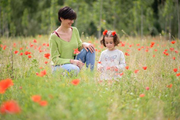 Мать со своей маленькой дочерью на маковом поле
 - Фото, изображение