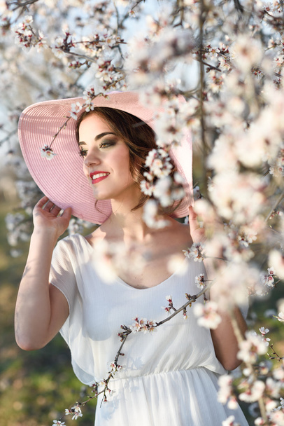 Portret van een jonge vrouw in de bloemrijke tuin in het voorjaar tim - Foto, afbeelding