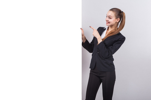 girl in a business suit stands next to the board for the text an - 写真・画像