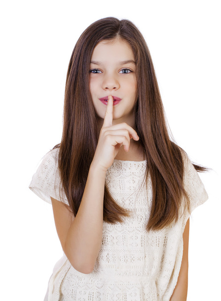 Little girl has put forefinger to lips as sign of silence - Foto, afbeelding