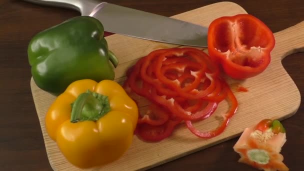 Резка и подготовка колбасных перцев на разделочной доске, включая красный, желтый и зеленый
 - Кадры, видео