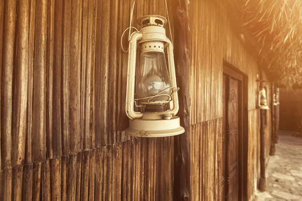 Oude ouderwetse vintage kerosine lantaarn olielamp met leeftijd houten muur - Foto, afbeelding