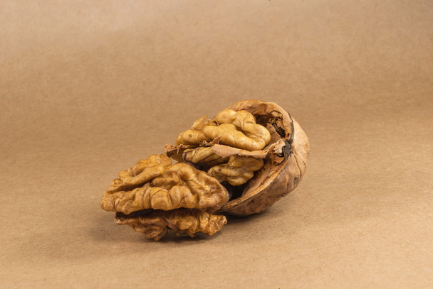 Walnut kernels en hele walnoten op kraft paperf, close-up - Foto, afbeelding