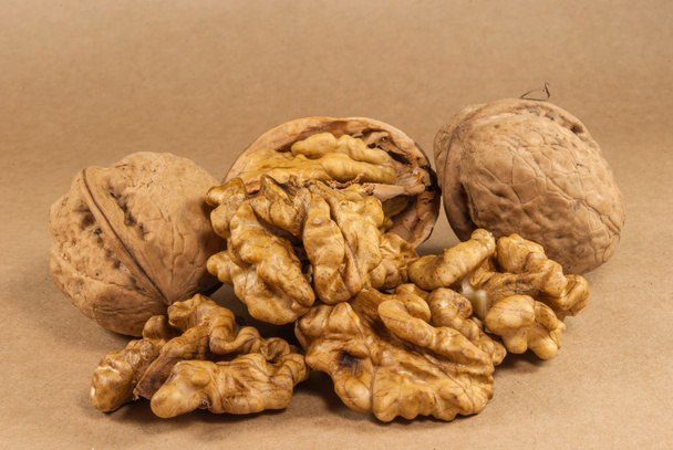Walnut kernels and whole walnuts on kraft paperf, close up - Photo, Image