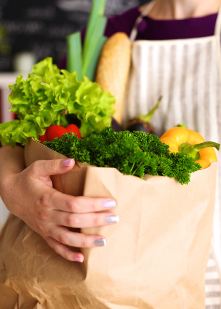 Vegyes gyümölcsök és zöldségek barna élelmiszerbolt táska gazdaság egy fiatal lány - Fotó, kép