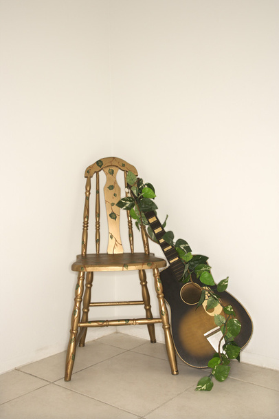 Guitar leaning on chair. - Foto, Bild