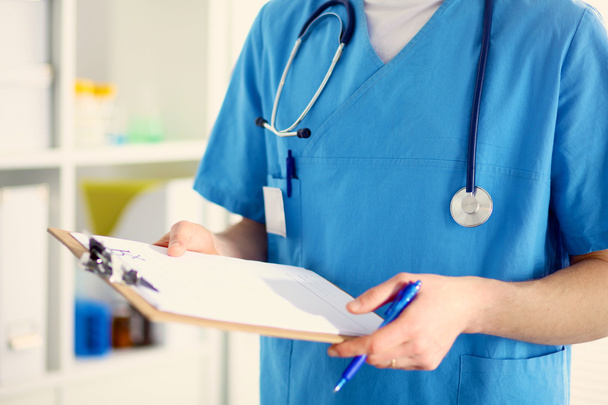 Closeup portrait of a  doctor with stethoscope holding folder - Фото, изображение